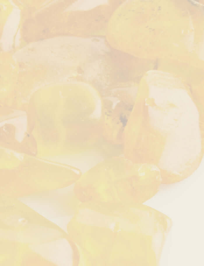 Close-up of translucent myrrh resin in deep amber and golden hues, illuminated by soft light.
