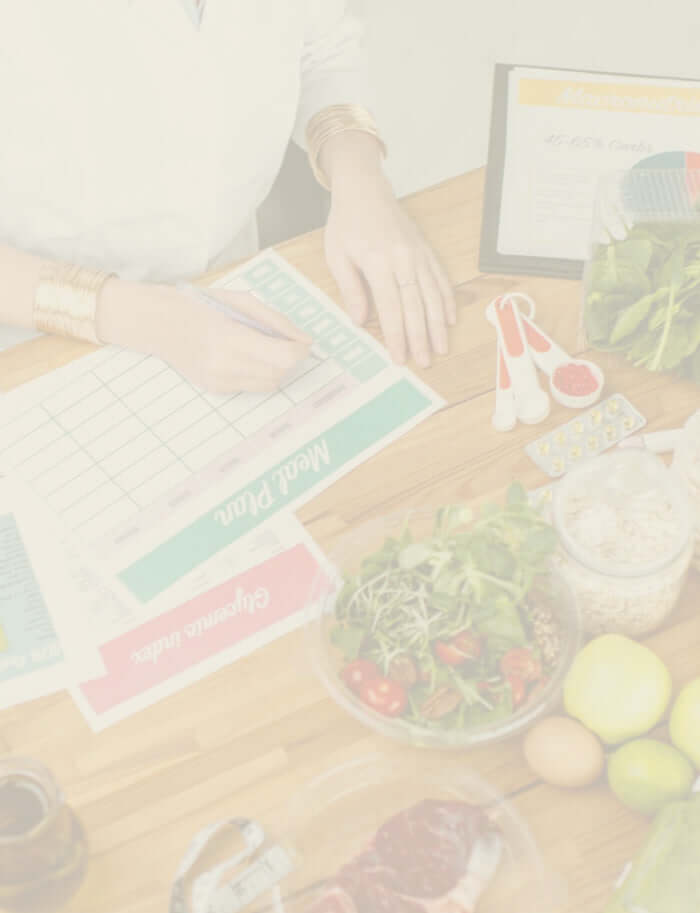 Nutritionist writing a meal plan surrounded by healthy food choices.