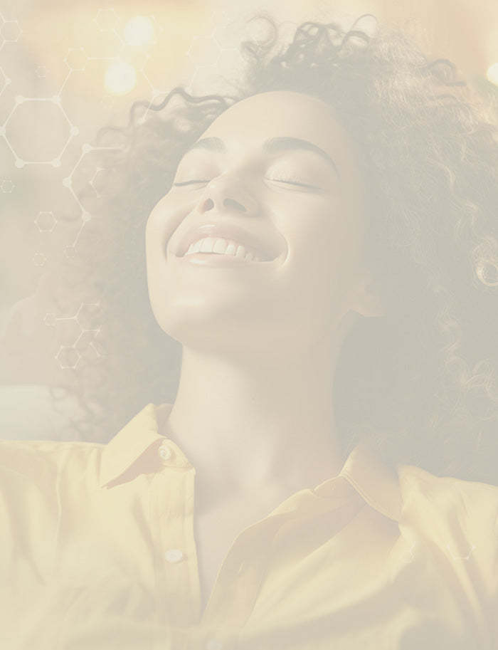 A woman in a yellow shirt smiling with her eyes closed