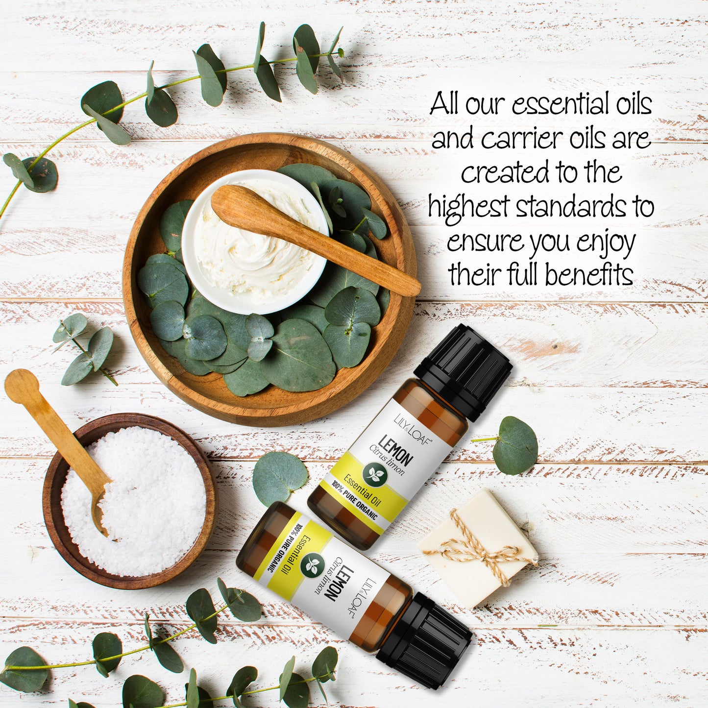 Organic Lemon Essential Oil bottles surrounded by wooden bowls filled with bath salts and lotions.