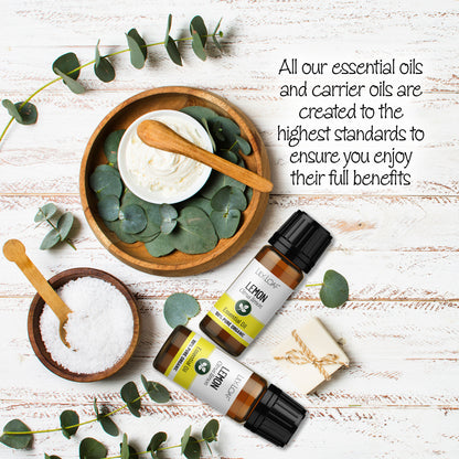 Organic Lemon Essential Oil bottles surrounded by wooden bowls filled with bath salts and lotions.