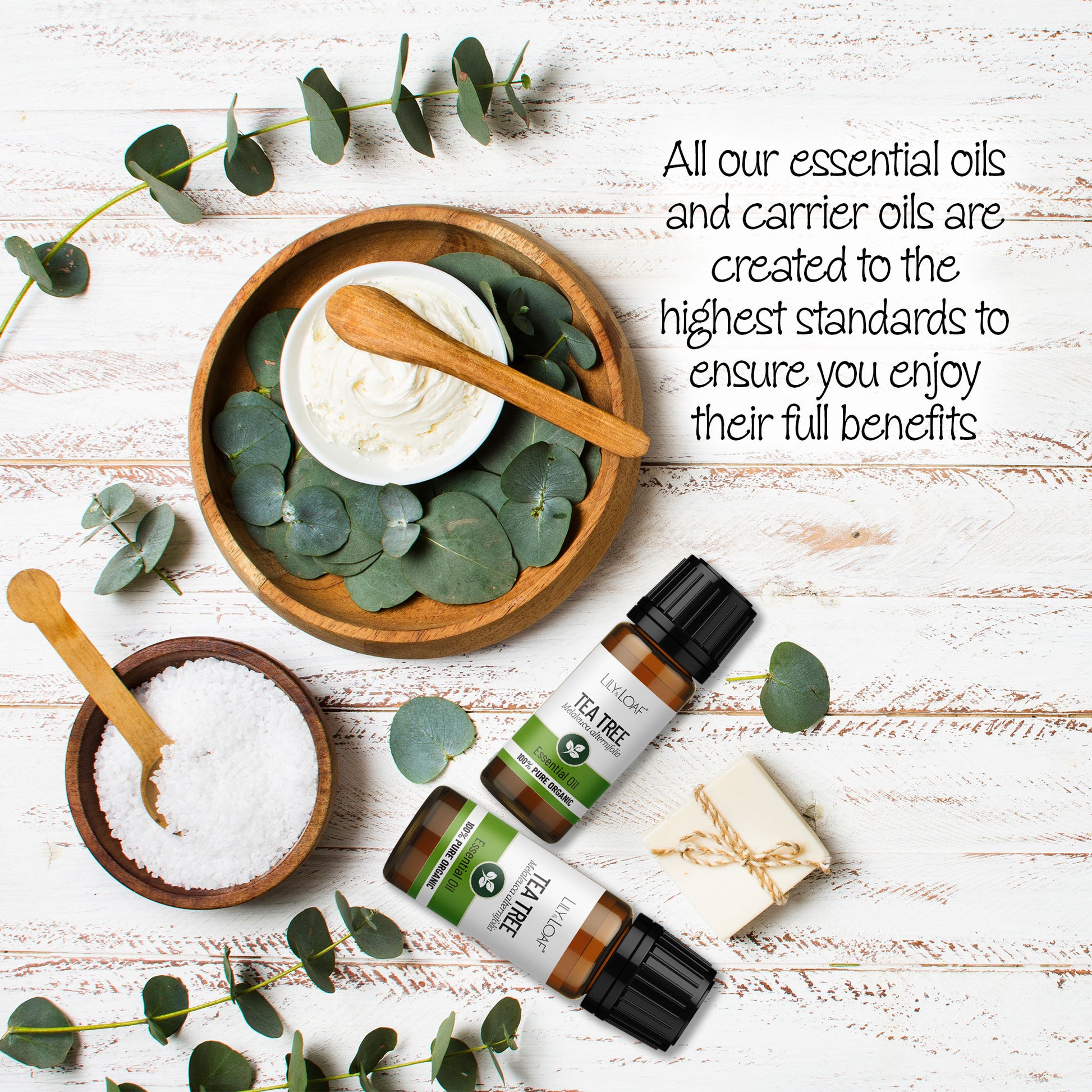 Tea Tree Organic Essential Oil surrounded by bath salts, cream and eucalyptus leaves depicting the high standards of creation